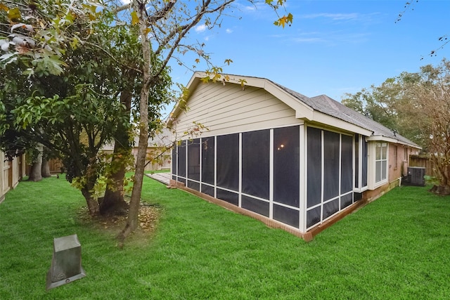 back of house featuring a yard, a fenced backyard, and a sunroom