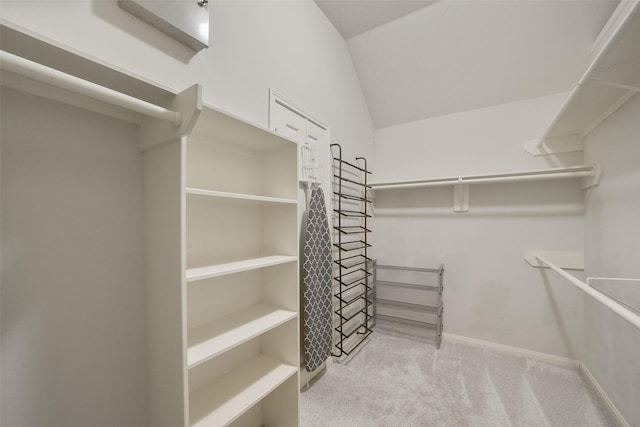 walk in closet with carpet and vaulted ceiling