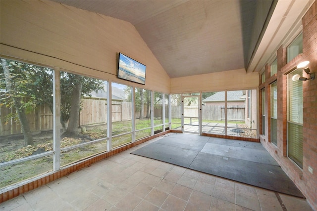 unfurnished sunroom featuring vaulted ceiling