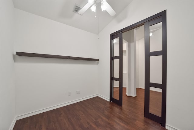 spare room featuring lofted ceiling, wood finished floors, a ceiling fan, visible vents, and baseboards