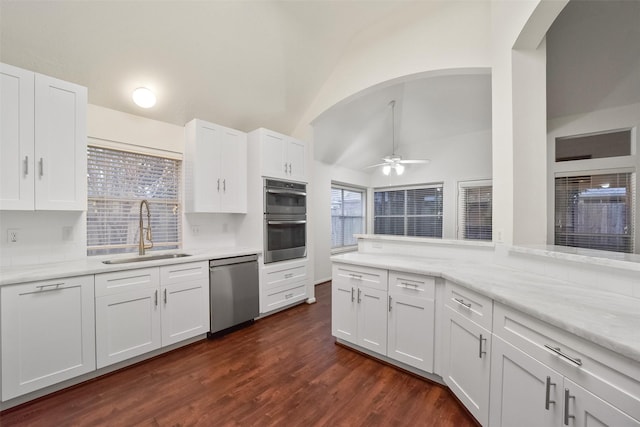 kitchen with dark wood-style flooring, backsplash, appliances with stainless steel finishes, white cabinets, and a sink