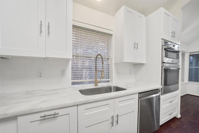 kitchen featuring a wealth of natural light, appliances with stainless steel finishes, decorative backsplash, and a sink