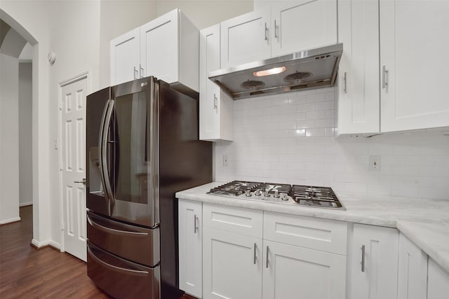 kitchen featuring under cabinet range hood, stainless steel appliances, dark wood-style flooring, white cabinetry, and tasteful backsplash