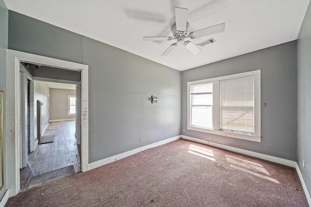 empty room with carpet floors, baseboards, and visible vents