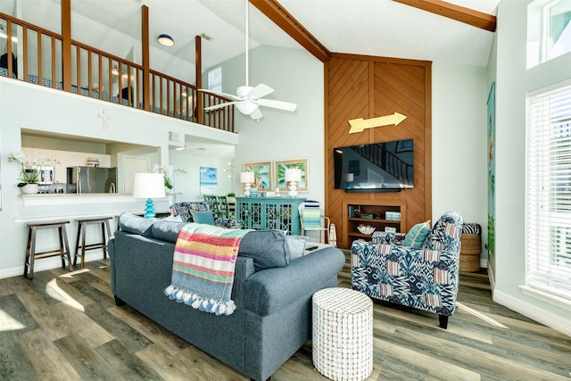 living area featuring high vaulted ceiling, wood finished floors, a ceiling fan, and baseboards