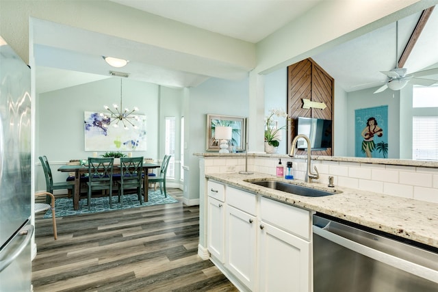 kitchen featuring lofted ceiling, a sink, appliances with stainless steel finishes, light stone countertops, and tasteful backsplash