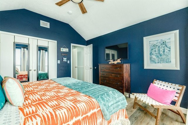 bedroom featuring lofted ceiling, wood finished floors, visible vents, a ceiling fan, and french doors