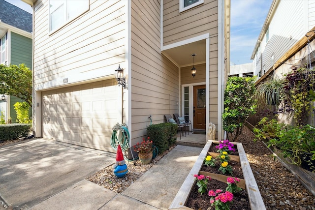 view of exterior entry with a garage and driveway