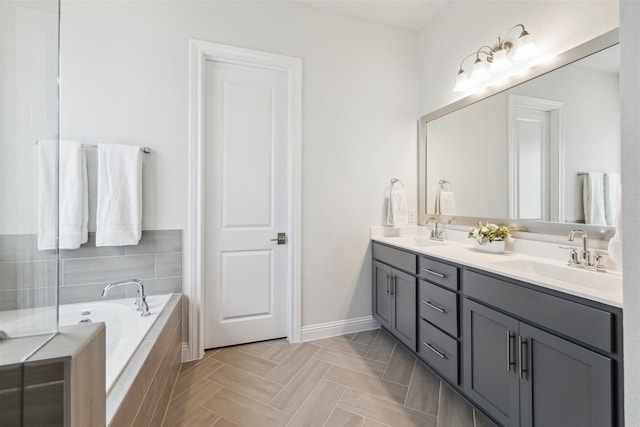 full bath with double vanity, baseboards, a sink, and a bath