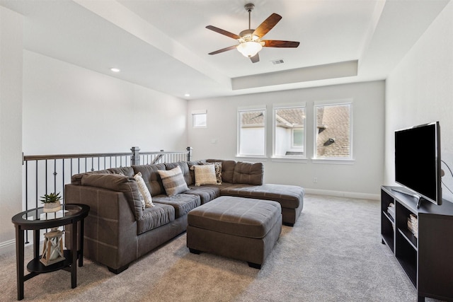 carpeted living room featuring a tray ceiling, recessed lighting, visible vents, a ceiling fan, and baseboards