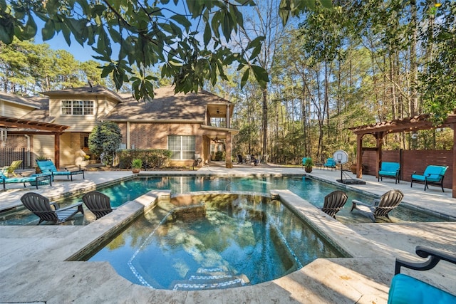 view of pool featuring a pool with connected hot tub, fence, a pergola, and a patio