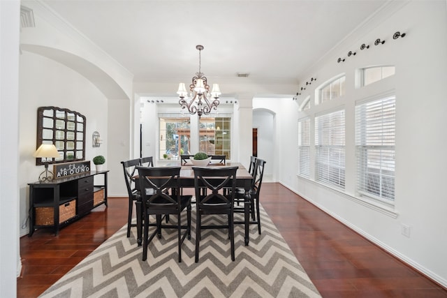 dining area featuring dark wood-style floors, ornamental molding, arched walkways, and visible vents