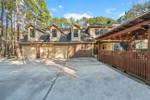 view of home's exterior with a garage, concrete driveway, brick siding, and roof with shingles