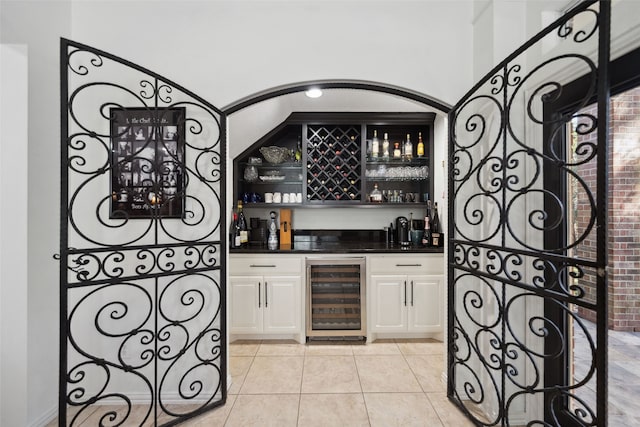 bar with beverage cooler, bar, and light tile patterned flooring