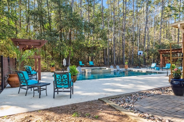 view of swimming pool featuring a patio area, a pool with connected hot tub, and fence