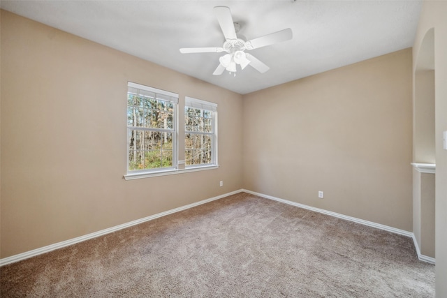 carpeted empty room with ceiling fan and baseboards