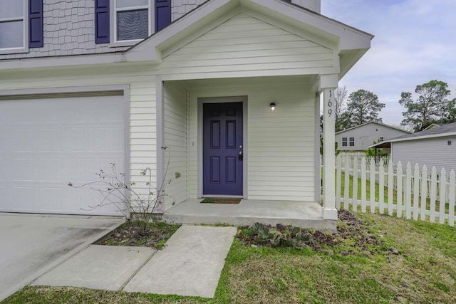 doorway to property featuring a garage and fence