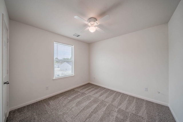 carpeted empty room with a ceiling fan, visible vents, and baseboards