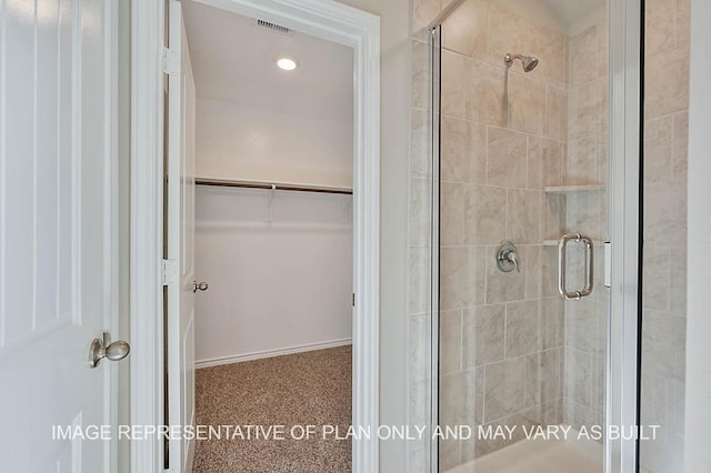 bathroom with visible vents, a shower stall, and a spacious closet