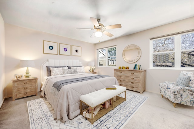 bedroom featuring ceiling fan, baseboards, and light colored carpet