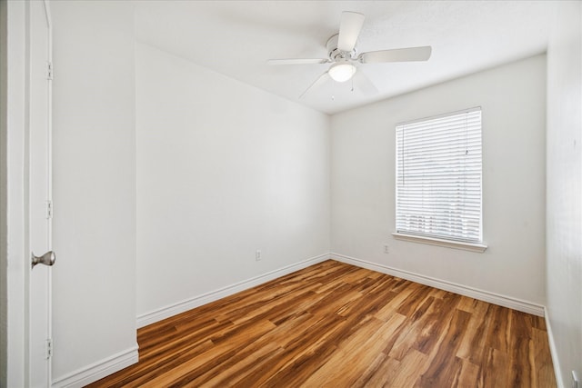 empty room featuring ceiling fan, wood finished floors, and baseboards