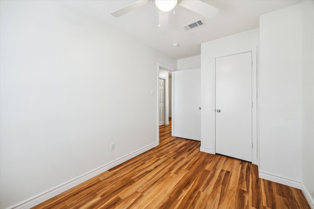 unfurnished bedroom with baseboards, visible vents, ceiling fan, and wood finished floors