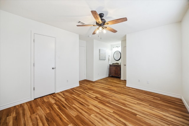 spare room featuring ceiling fan, light wood finished floors, visible vents, and baseboards