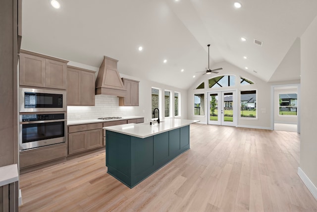 9975 Monarch Landing Cv, Willis, TX 77318 - kitchen with appliances with stainless steel finishes, custom range hood, healthy amount of natural light, light countertops, and high vaulted ceiling