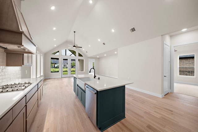 9975 Monarch Landing Cv, Willis, TX 77318 - kitchen with appliances with stainless steel finishes, open floor plan, light wood-style floors, light countertops, and decorative backsplash