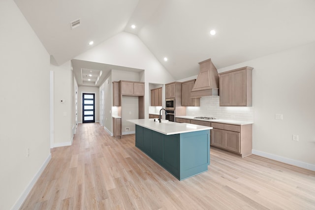 9975 Monarch Landing Cv, Willis, TX 77318 - kitchen featuring custom exhaust hood, stainless steel appliances, backsplash, recessed lighting, and light wood-style floors