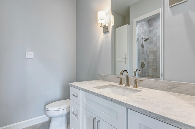 full bathroom featuring toilet, a shower stall, baseboards, and vanity