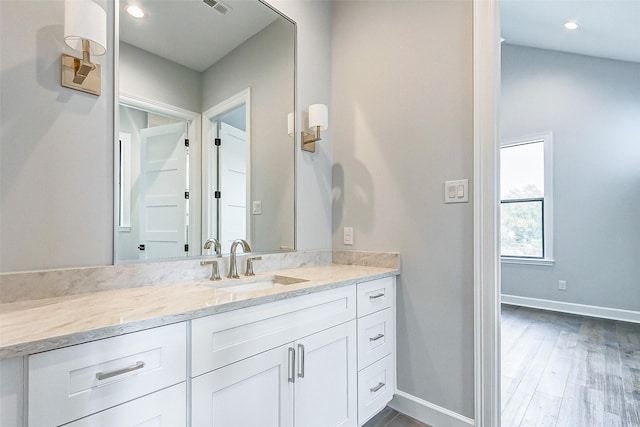 bathroom featuring recessed lighting, vanity, baseboards, and wood finished floors