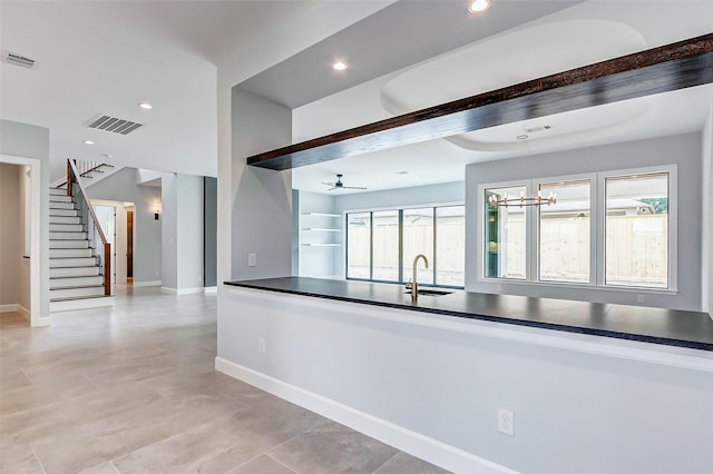 kitchen with dark countertops, a sink, and visible vents