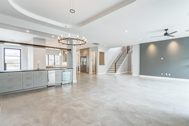 interior space featuring beverage cooler, baseboards, visible vents, stairway, and a tray ceiling