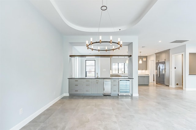 kitchen featuring baseboards, wine cooler, built in refrigerator, and gray cabinetry