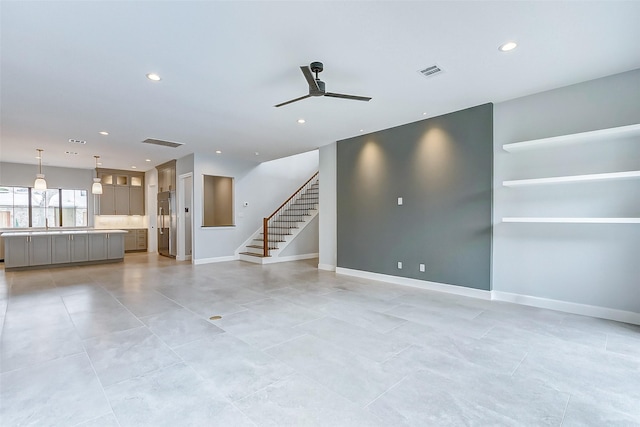 unfurnished living room featuring recessed lighting, visible vents, and stairway