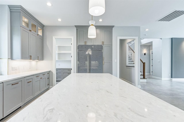 kitchen featuring visible vents, glass insert cabinets, light stone countertops, gray cabinetry, and recessed lighting