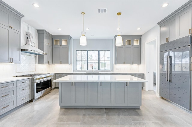 kitchen featuring a center island, visible vents, decorative backsplash, gray cabinetry, and high quality appliances