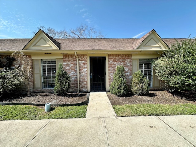 ranch-style house with brick siding and a shingled roof