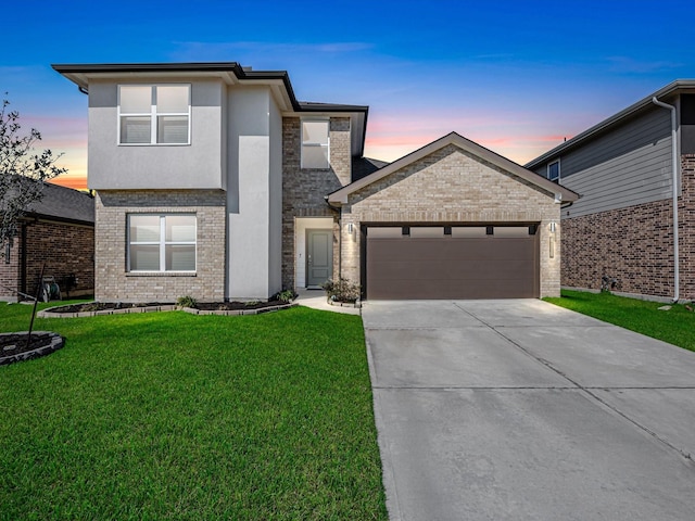 view of front of house featuring a garage, brick siding, concrete driveway, a yard, and stucco siding