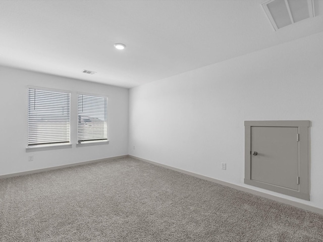 unfurnished room featuring carpet floors, visible vents, and baseboards