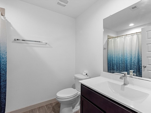 full bath featuring toilet, visible vents, wood finished floors, and vanity