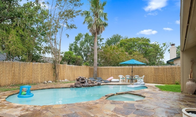 view of swimming pool with a pool with connected hot tub, a fenced backyard, and a patio