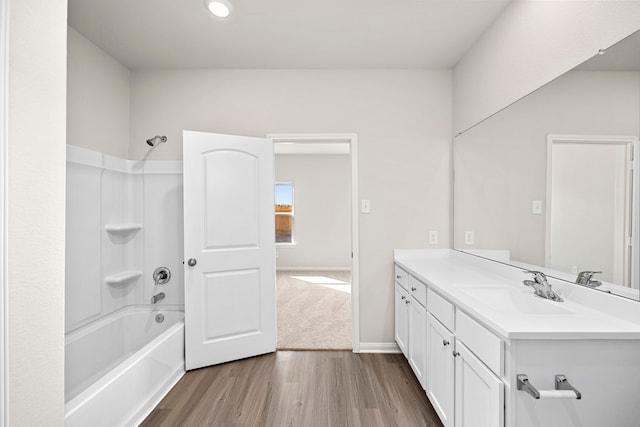 bathroom featuring bathing tub / shower combination, wood finished floors, vanity, and baseboards