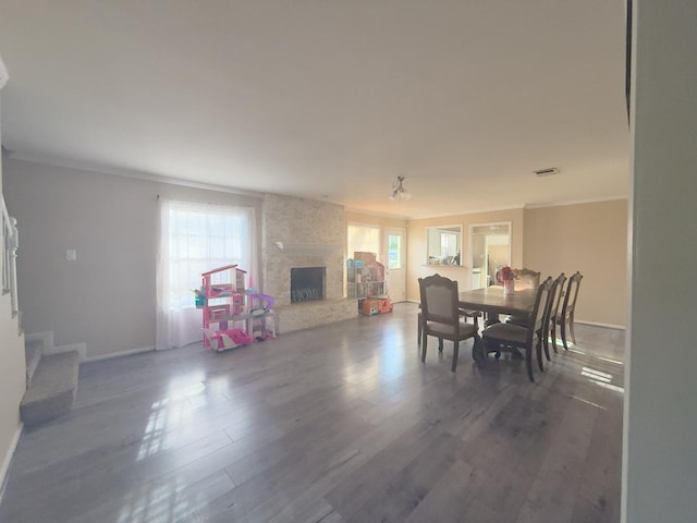 dining area featuring visible vents, wood finished floors, stairway, a fireplace, and baseboards