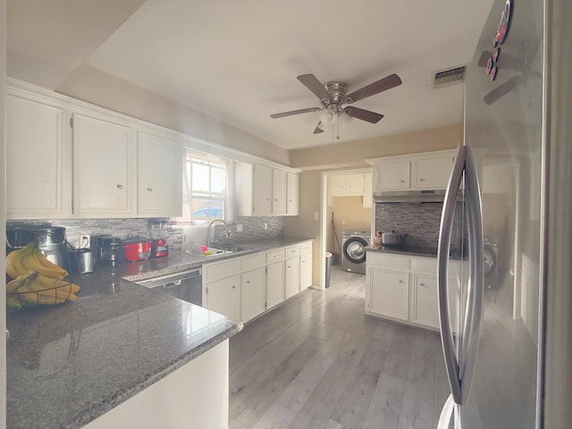 kitchen with visible vents, washer / dryer, a sink, light wood-style floors, and appliances with stainless steel finishes