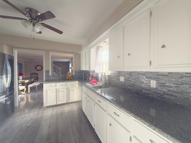 kitchen with backsplash, dark wood finished floors, stainless steel appliances, white cabinetry, and a sink