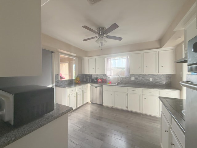 kitchen with dishwasher, tasteful backsplash, white cabinetry, and a sink