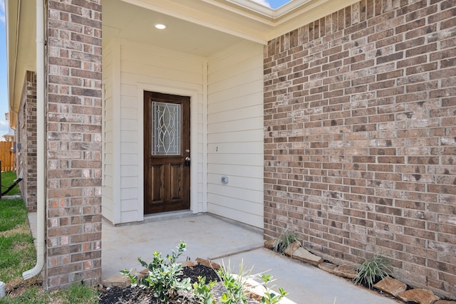 property entrance featuring brick siding