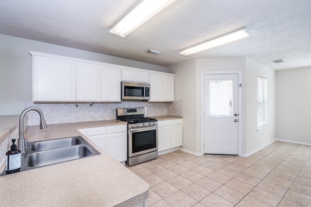 kitchen with a sink, white cabinetry, visible vents, appliances with stainless steel finishes, and tasteful backsplash